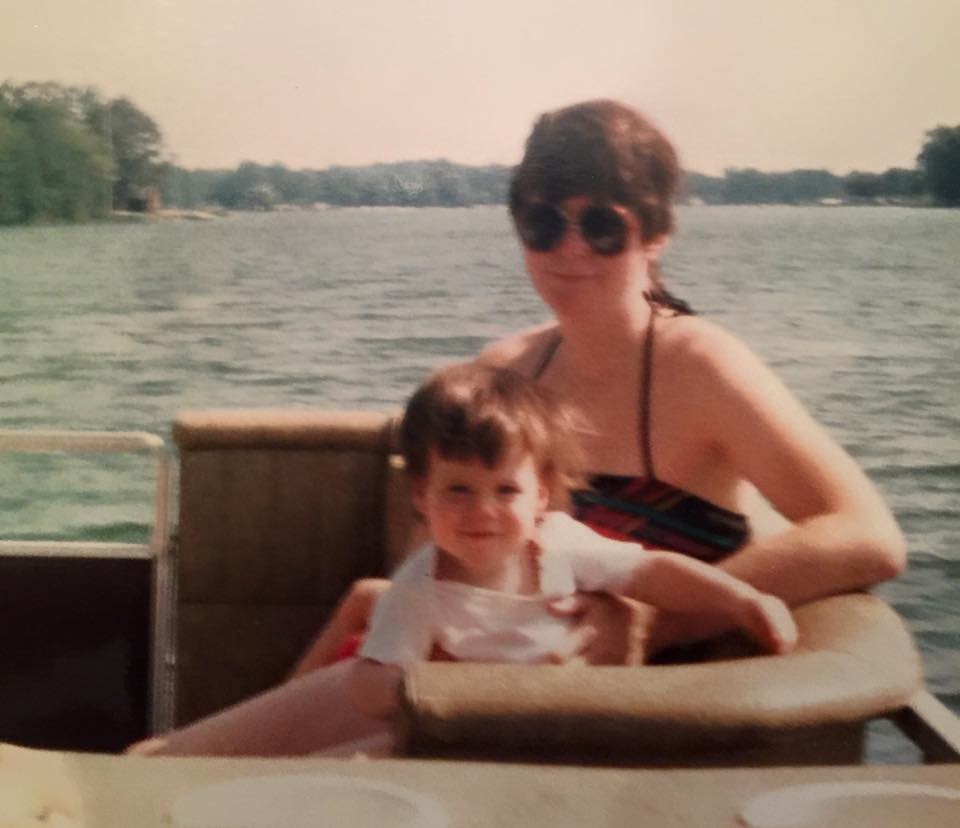 A mother and child smile on a boat.