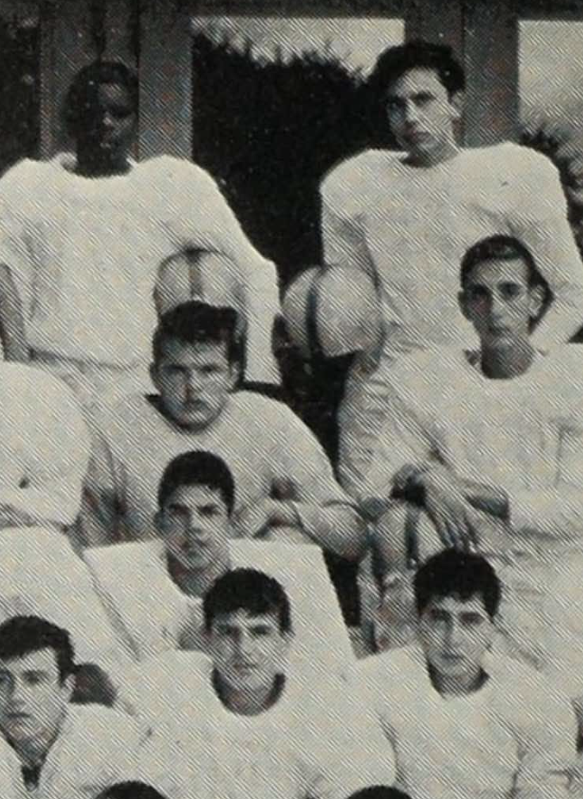 Close-up of a vintage black-and-white high school football team photo showing several players in uniforms posing for a team portrait