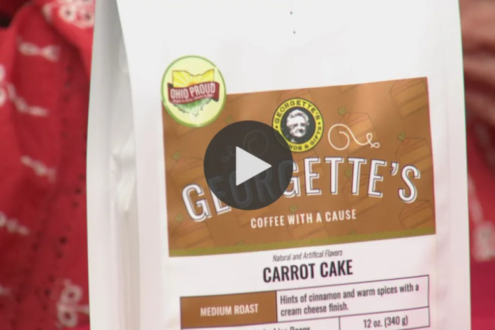 A hand holding a bag of carrot cake coffee