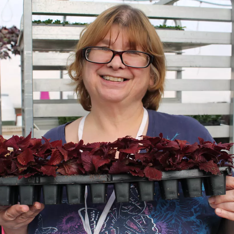 A Woman Smiling While Holding Flowers